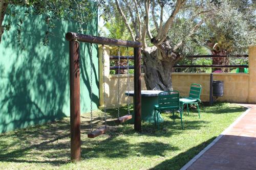 a playground with a table and chairs next to a tree at Casas Guemon in Zahora