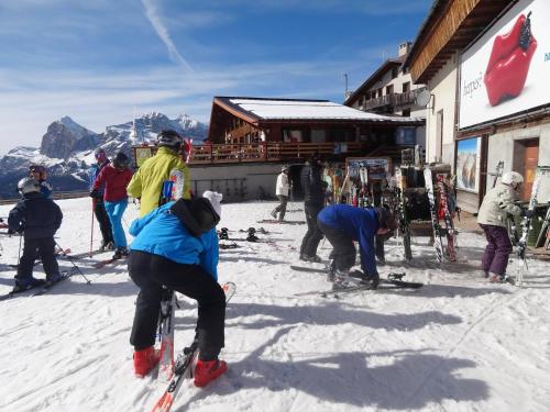 a group of people on skis in the snow near a building at Hotel Pontechiesa in Cortina dʼAmpezzo