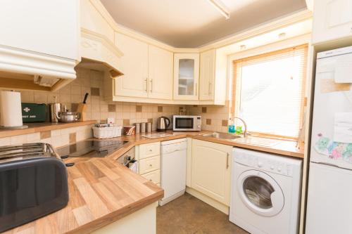a kitchen with white cabinets and a washer and dryer at Excellent Location - City Centre - Parking - 4 Beds -2 Bedrooms in Belfast