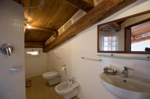 uma casa de banho com um lavatório, um WC e um espelho. em Maiorca 24 Apartments em Alghero
