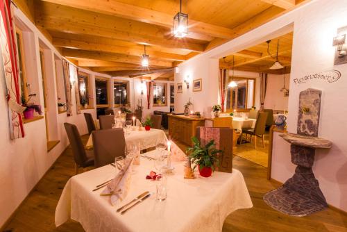 uma sala de jantar com mesas e cadeiras e um restaurante em Alpenhof Wolayersee em Birnbaum