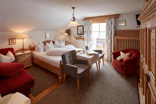 una camera d'albergo con letto, tavolo e sedie di Gintherhof a Reutte