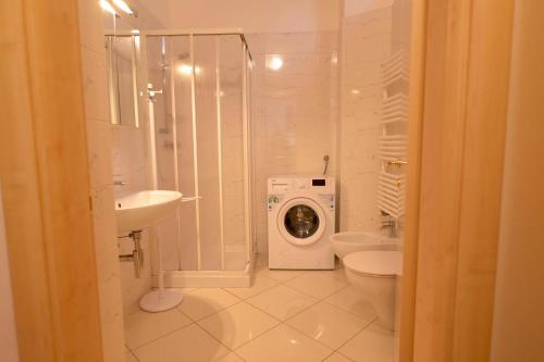 a bathroom with a washing machine and a washer at Casa Josa - WelcHome in Cannobio