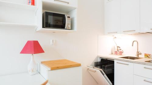 a small kitchen with a sink and a microwave at Vironkatu 3 in Helsinki