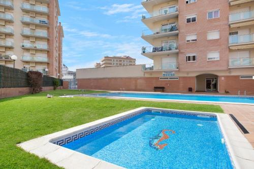 una piscina vacía en un patio junto a un edificio en Europa Square Apartment, en Santa Susanna