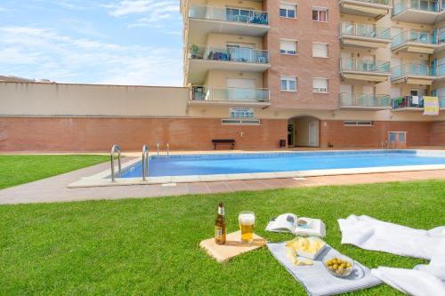 a table with food and drinks next to a swimming pool at Europa Square Apartment in Santa Susanna