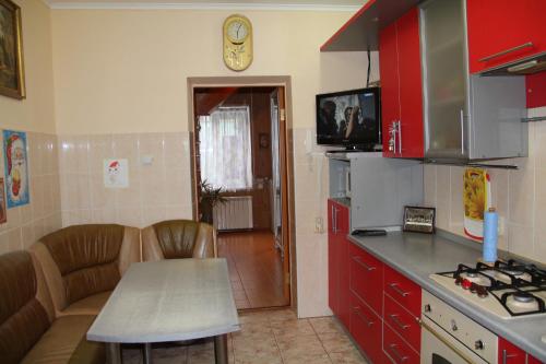 エイスクにあるВ гостях у Любвиの赤いキャビネットとテーブル、カウンター付きのキッチン