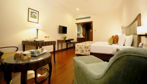 a hotel room with a bed and a living room at Muse Sarovar Portico Nehru Place in New Delhi