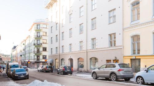 a city street with cars parked in front of buildings at Vironkatu 3 in Helsinki