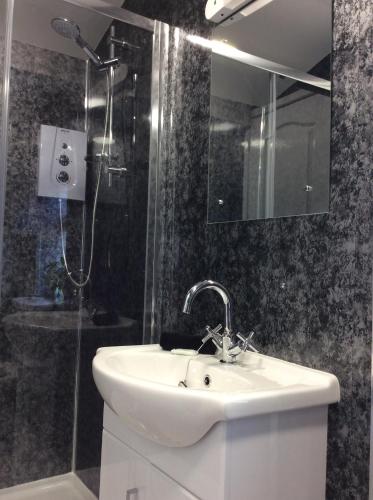 un baño con lavabo y ducha en The Westbourne Guest House, en Llandudno