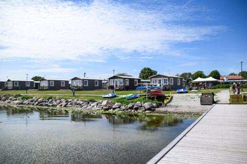 a river with houses in the background and a dock at Slite Strand resort in Slite