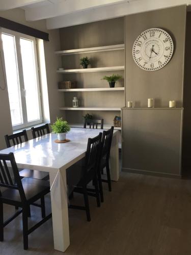une salle à manger avec une table et une horloge au mur dans l'établissement Les Roches Yportaises, à Yport
