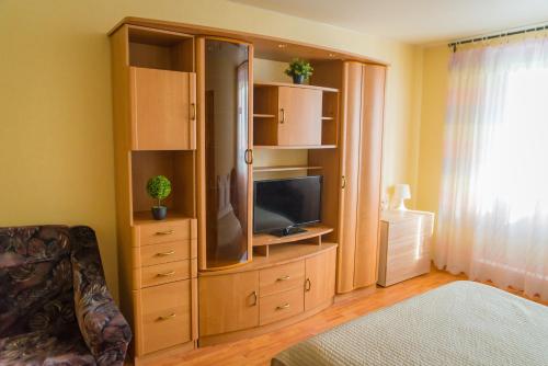 モスクワにあるInnDays on Lazarevaのベッドルーム1室(テレビ付きの木製の大型エンターテイメントセンター付)
