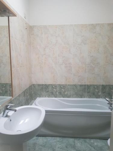 La salle de bains est pourvue d'une baignoire blanche et d'un lavabo. dans l'établissement Lecco centro - casa indipendente, à Lecco
