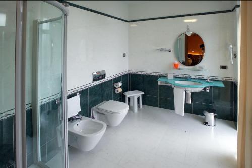 y baño con aseo, lavabo y ducha. en Albergo Ristorante San Marco, en Carmagnola