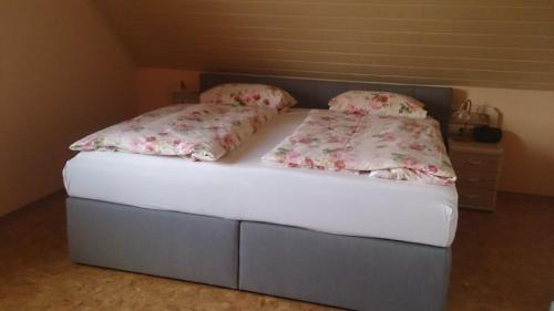 a bed with two pillows on it in a room at Ferienwohnung Maria Waldblick 95 qm, in Burtenbach