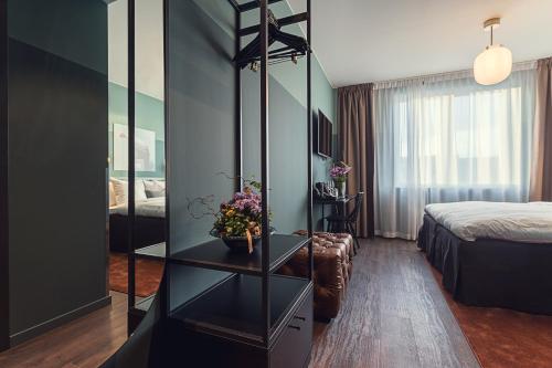 a hotel room with a bed and a table with flowers at Best Western Plus Hus 57 in Ängelholm