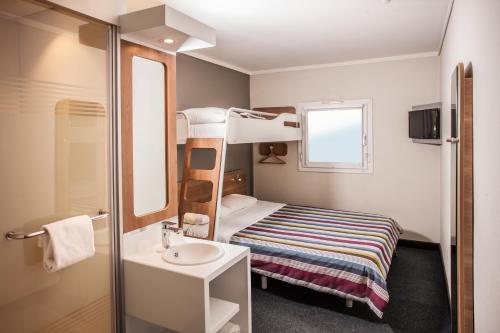 SUN1 WITBANK في ويتبانك: غرفة صغيرة مع سرير بطابقين ومغسلة
