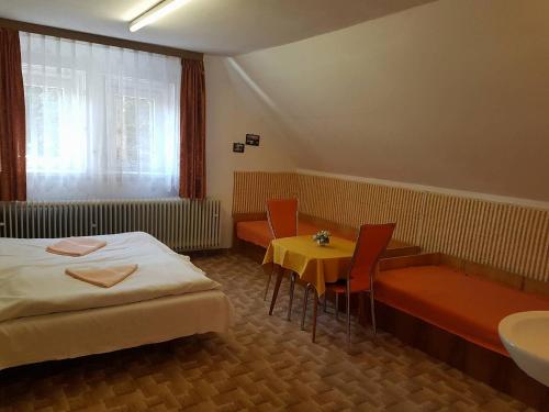 a hotel room with a bed and a table and chairs at Vila Zdenka in Vysoke Tatry - Tatranska Kotlina