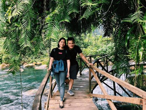 a man and a woman walking across a bridge at Carambola Bungalow in Phong Nha