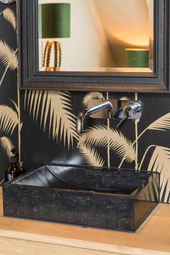 a bathroom with a black sink and a mirror at Boutiquehotel 't Gerecht in Heerenveen