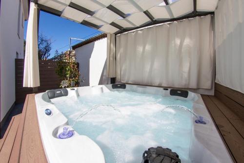 a jacuzzi tub on a deck with an umbrella at Apartment L Rovinj with Private Jacuzzi in Rovinj