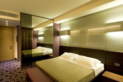 a hotel room with two beds and a mirror at Viola Mhotel in Grumello del Monte