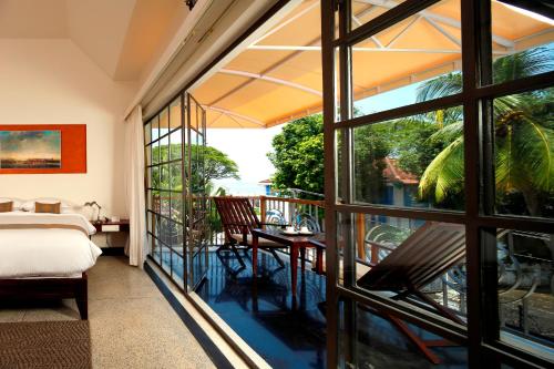 a room with a bed and a view of a balcony at Eighth Bastion Fort Kochi - CGH Earth in Cochin