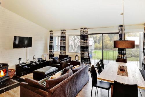 a living room with a couch and a table at Condo 09 Chemin des Abruzzes by Les Chalets Alpins in Stoneham