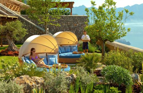 two people in a garden with two tents at Monastero Santa Rosa Hotel & Spa in Conca dei Marini