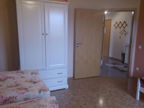 Schlafzimmer mit einem Bett, einer Kommode und einem Spiegel in der Unterkunft Ferienwohnung Maria Waldblick in Burtenbach