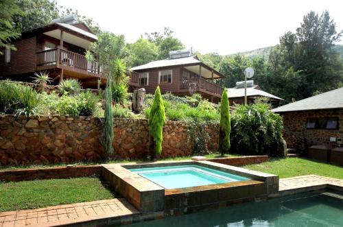 a backyard with a swimming pool and a house at Zongororo Village of Ministry in Waterval-Onder