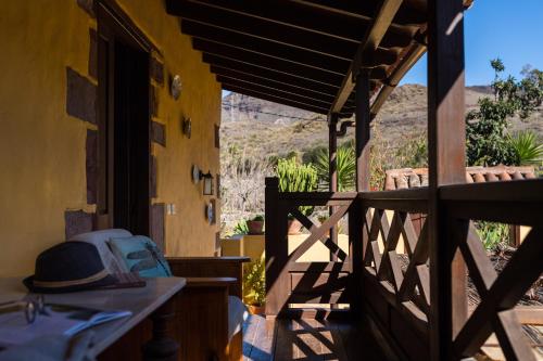 a porch of a house with a hat on it at Bohemian Hideaway Finca - 2 unique houses with shared pool in Santa Lucía