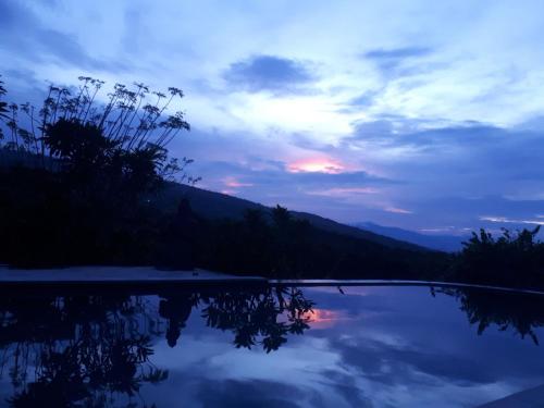 a sunset over a swimming pool at dusk at Lovina Paradise in Lovina