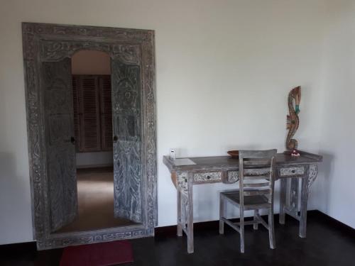 a table with a mirror next to a table with a chair at Lovina Paradise in Lovina