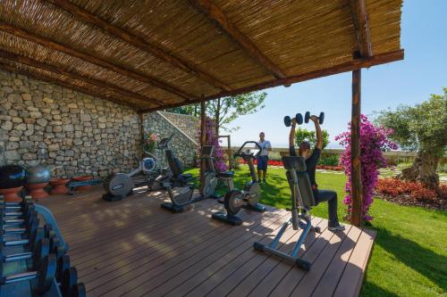 a gym with exercise equipment on a deck at Monastero Santa Rosa Hotel & Spa in Conca dei Marini