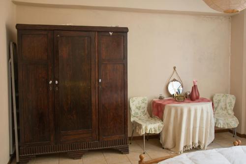 Pokój ze stołem i dużą drewnianą szafką w obiekcie Corfu Retreat w Korfu