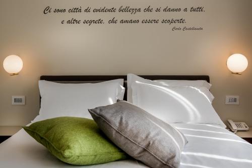 a bedroom with a bed with a quote on the wall at Hotel Canada in Milan