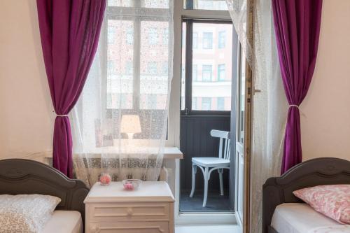 モスクワにあるLuxury Art Apartmentのベッドルーム1室(ベッド1台付)、紫色のカーテン付きの窓が備わります。