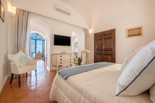 a bedroom with a bed and a desk and a chair at Casa Passalacqua in Positano