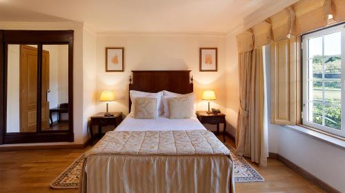 a bedroom with a bed and a large window at Turim Club D'Azeitao Hotel in Setúbal