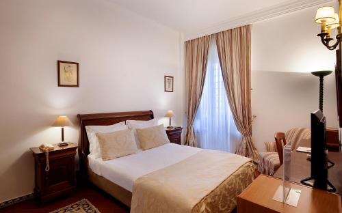a bedroom with a large bed and a large window at Hotel Club d'Azeitao in Setúbal