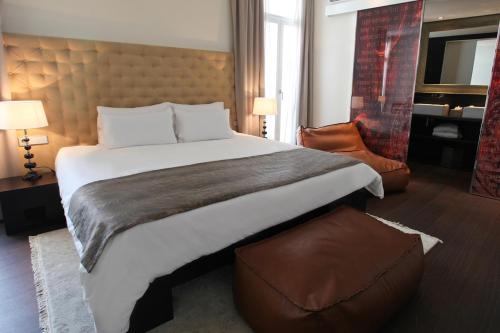 a hotel room with a large bed and a chair at Puro Hotel Oasis Urbano in Palma de Mallorca