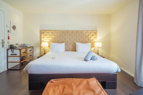 a large white bed in a room with two lamps at Puro Hotel Oasis Urbano in Palma de Mallorca