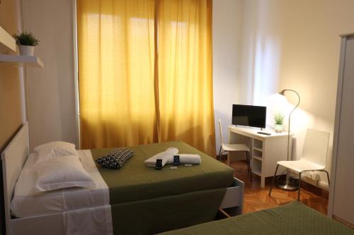 a bedroom with a bed and a desk with a computer at Guest House Pirelli Milano in Milan