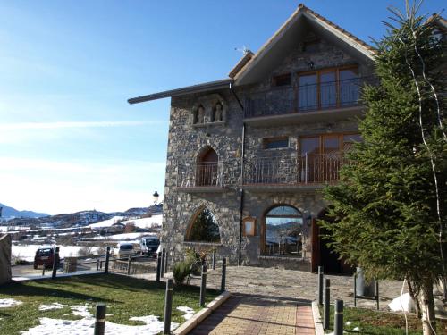 une maison dans les montagnes avec de la neige au sol dans l'établissement El Churrón, à Larrés