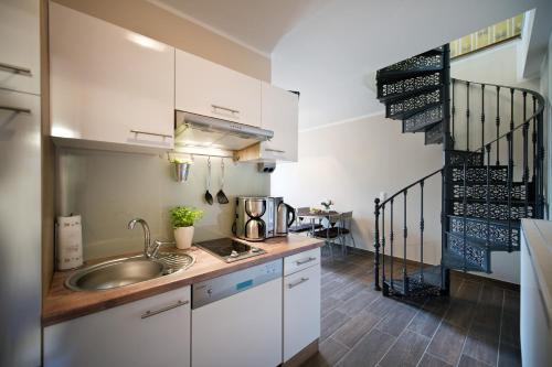 a kitchen with white cabinets and a sink at Guest house Villa Fritz in Potsdam