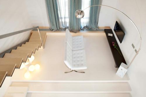 a living room with stairs and a white chair at Hotel AF Pesquera in Peñafiel