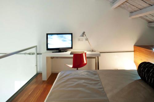 a bedroom with a bed and a desk with a computer monitor at Hotel AF Pesquera in Peñafiel