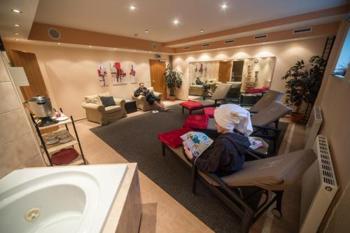 a bathroom with a sink and a person sitting in a chair at Landgut Stemmen in Stemmen